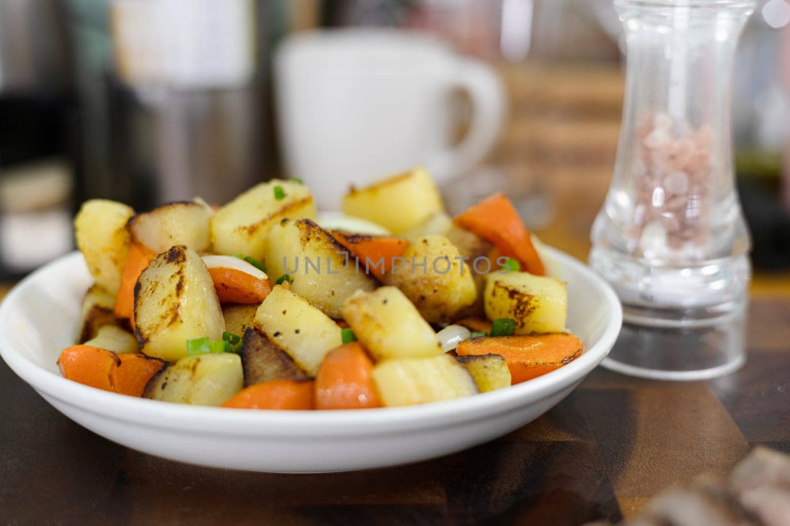 Golden Potatoes Are Fried With Carrot And Onion On A Plate by urzine