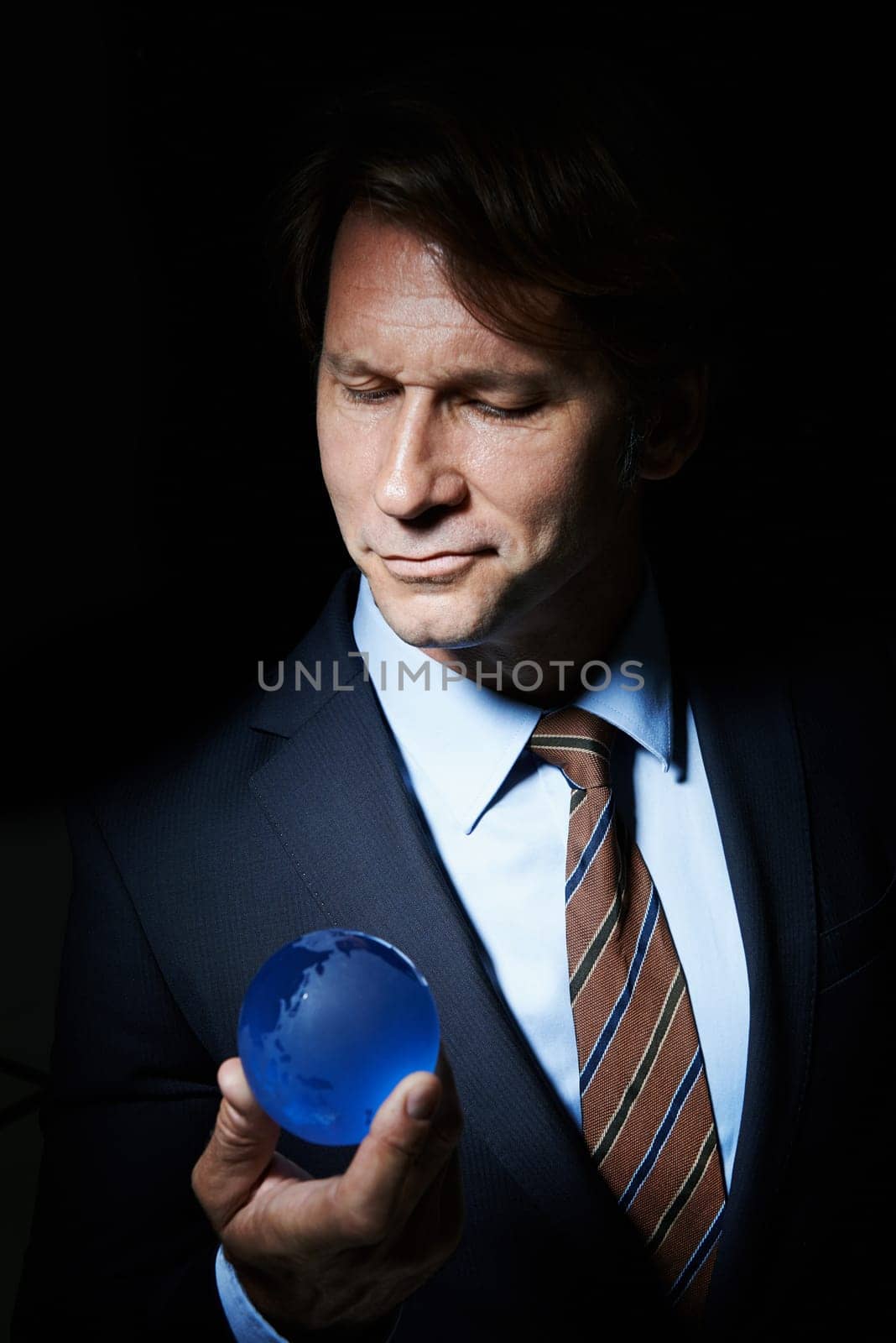 Man, suit and orb in studio for globe or earth for communication and connectivity in business. Leader or ceo with sphere, crystal or circle in hand for economy, world or future for corporate by YuriArcurs