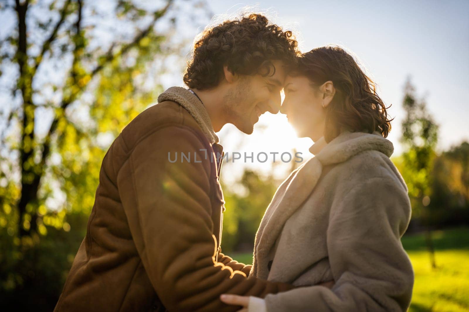 Portrait of happy loving couple in park in sunset.