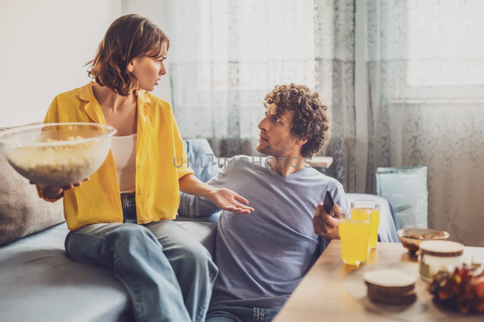 Man and woman are sitting at sofa and arguing. Relationship problems.