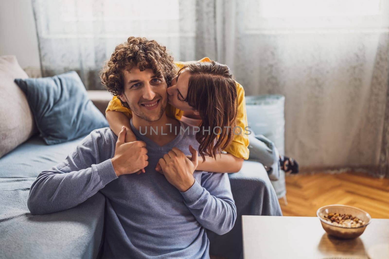 Young couple is embracing and kissing at their home.