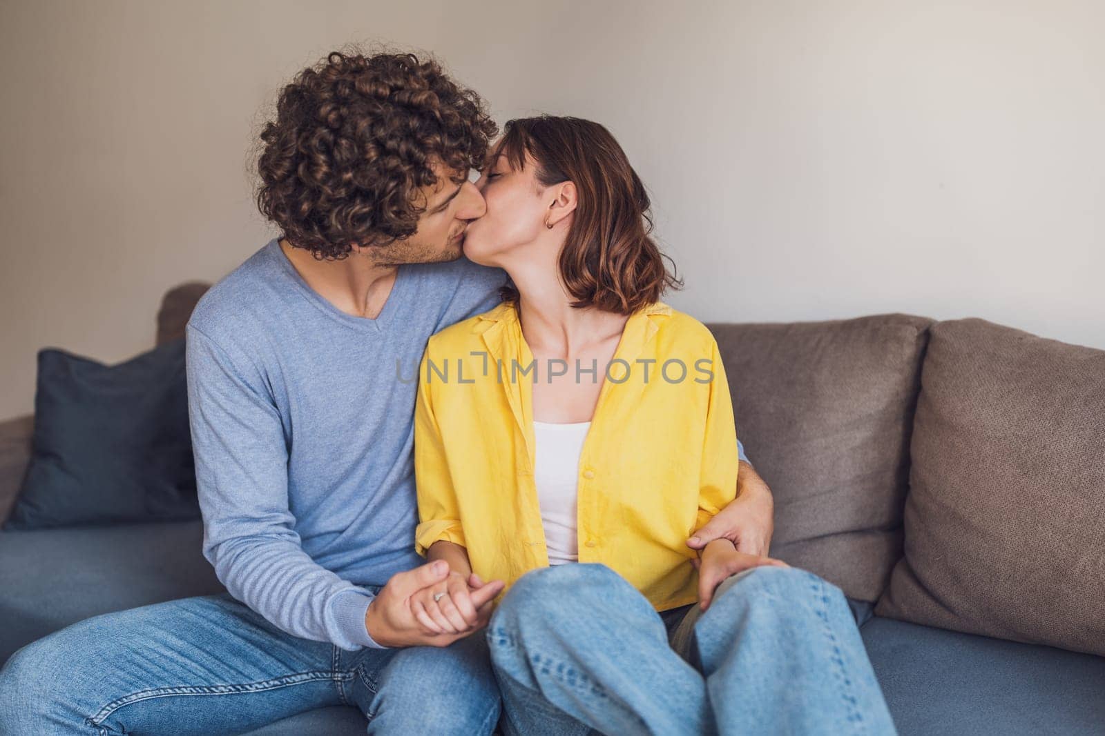 Young couple is embracing and kissing at their home.