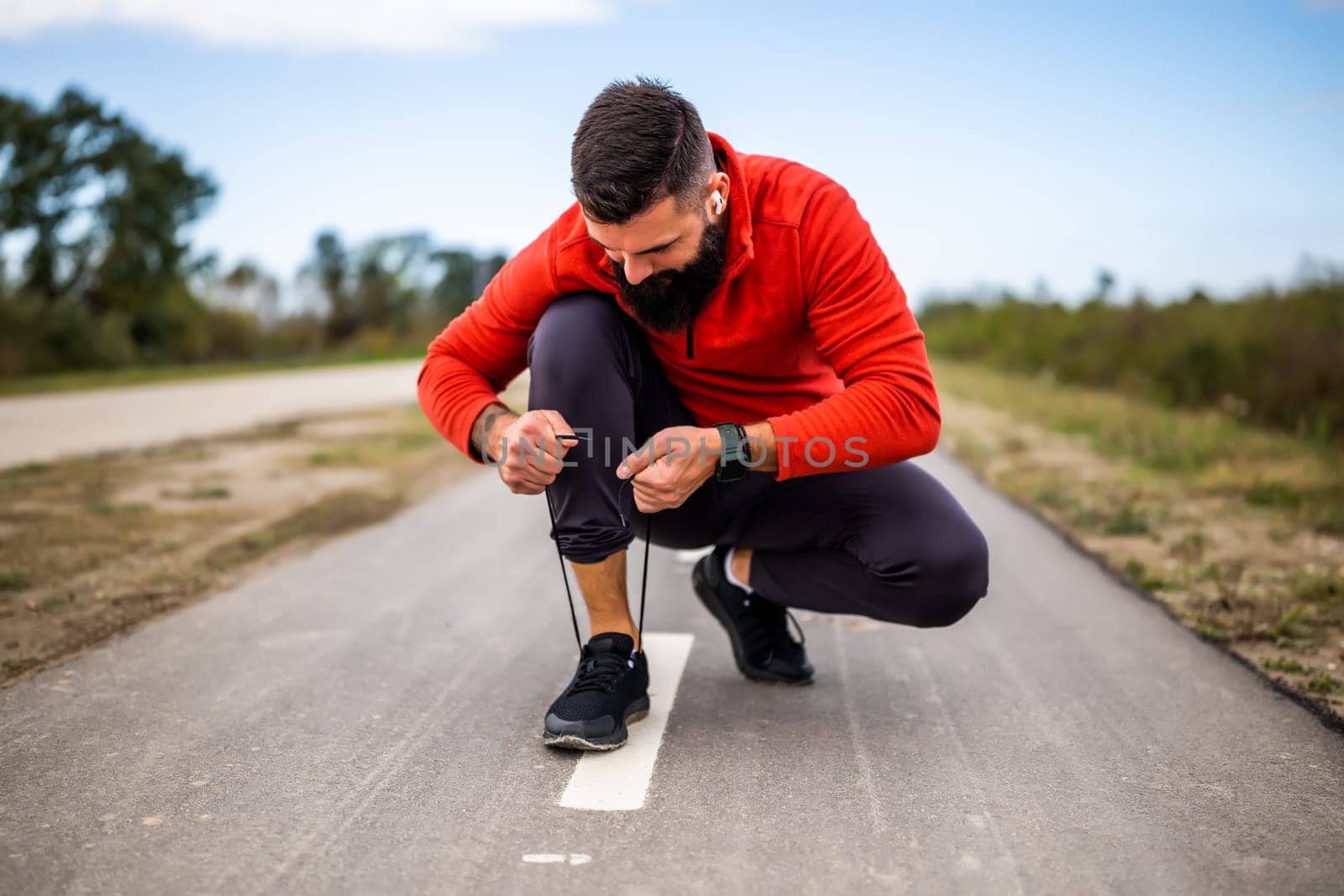 Young man is tying a shoelace before jogging.