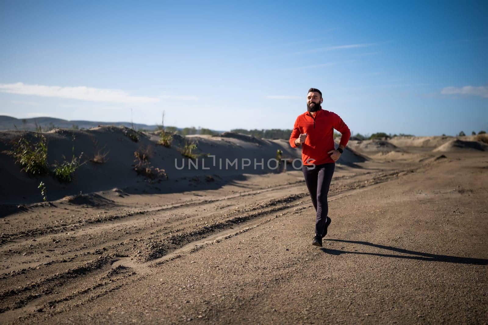 Adult man is jogging outdoor on sunny day.