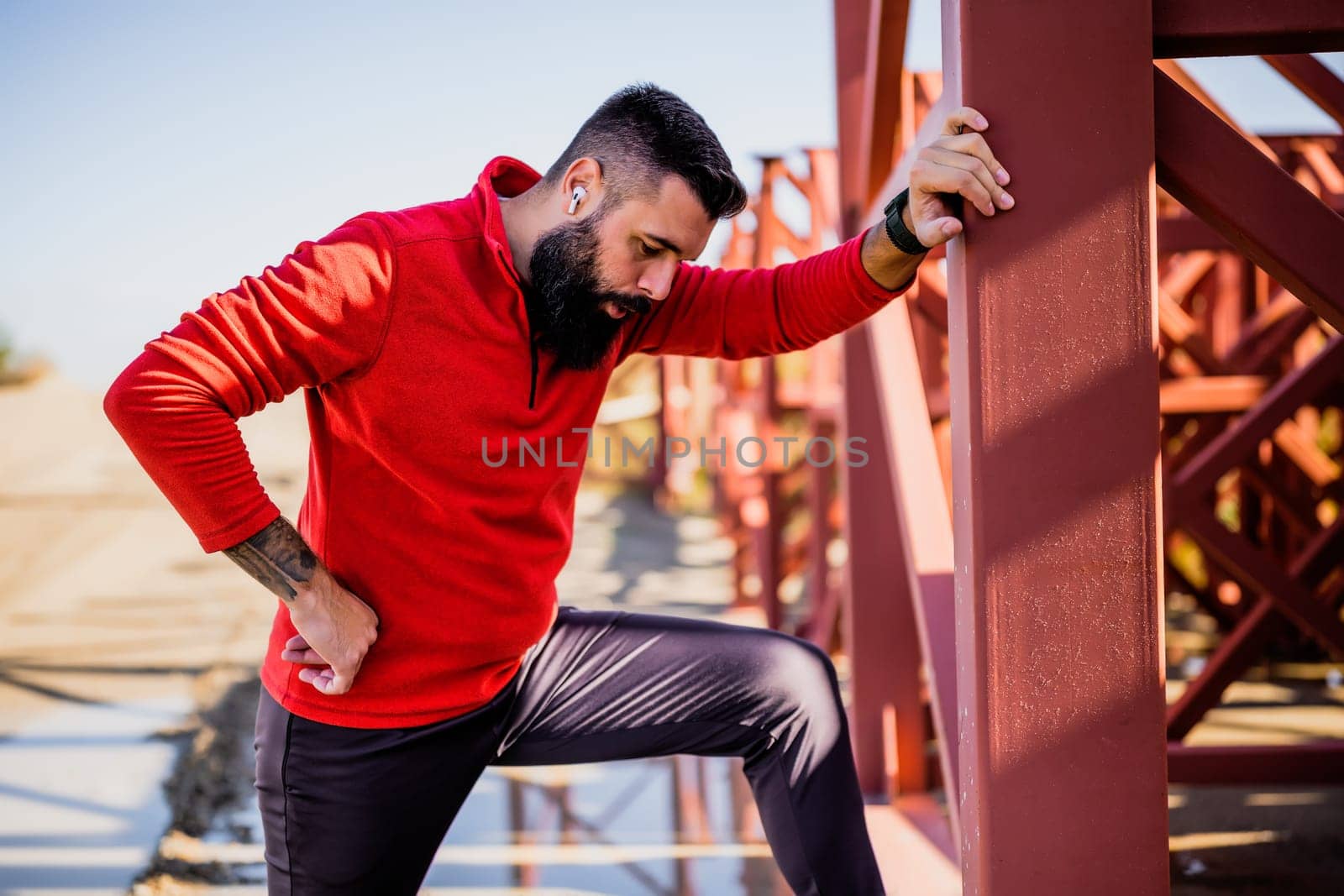 Adult man is relaxing while exercising outdoor on sunny day.