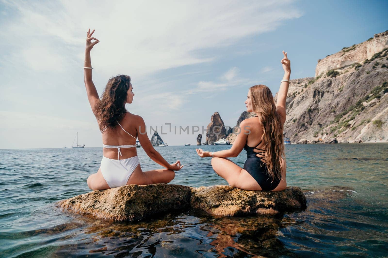 Woman sea yoga. Back view of free calm happy satisfied woman with long hair standing on top rock with yoga position against of sky by the sea. Healthy lifestyle outdoors in nature, fitness concept.