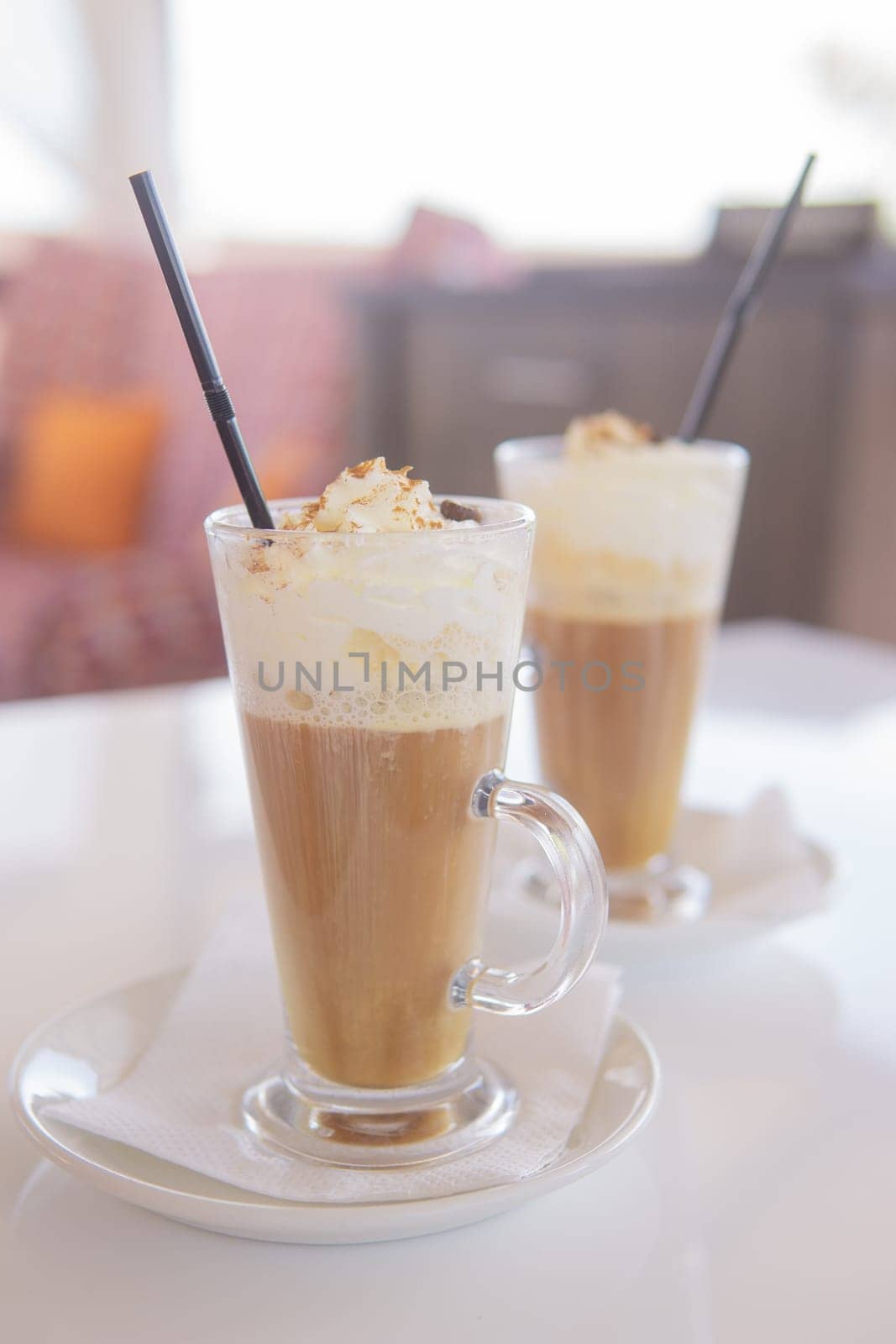 coffee is served in a tall glass glass with a straw. The concept of coffee drinks from the bar menu.