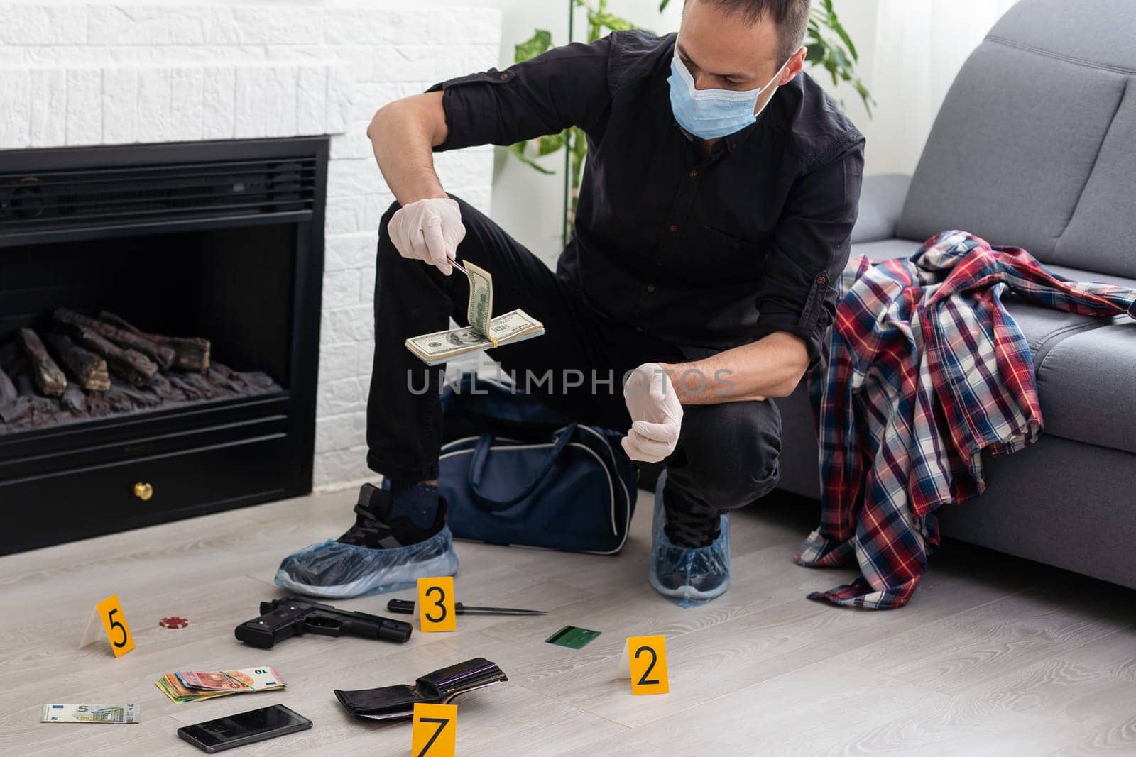 Criminological expert collecting evidence at the crime scene. High quality photo