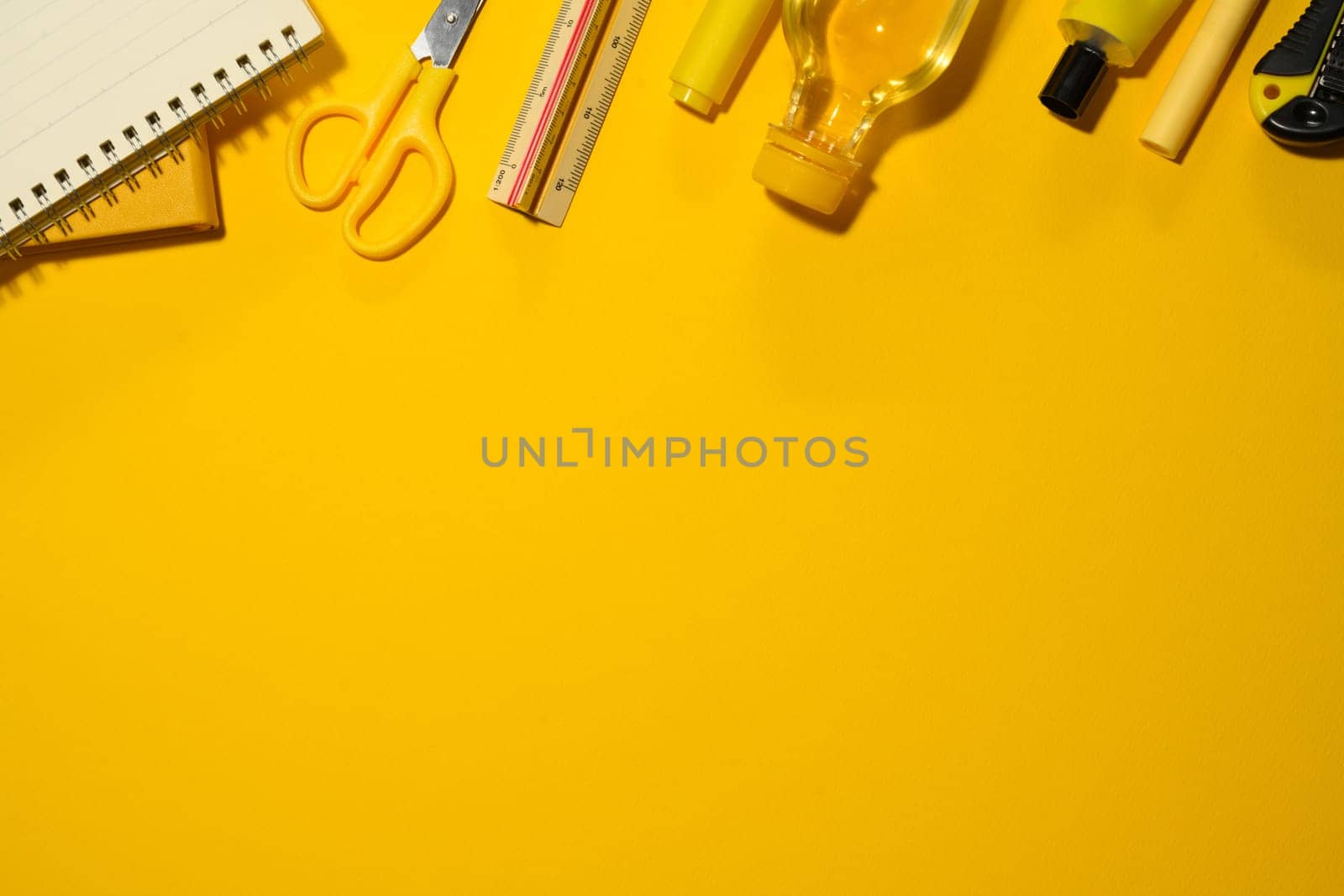 Various office and school supplies on yellow background. Flat lay, top view with copy space.
