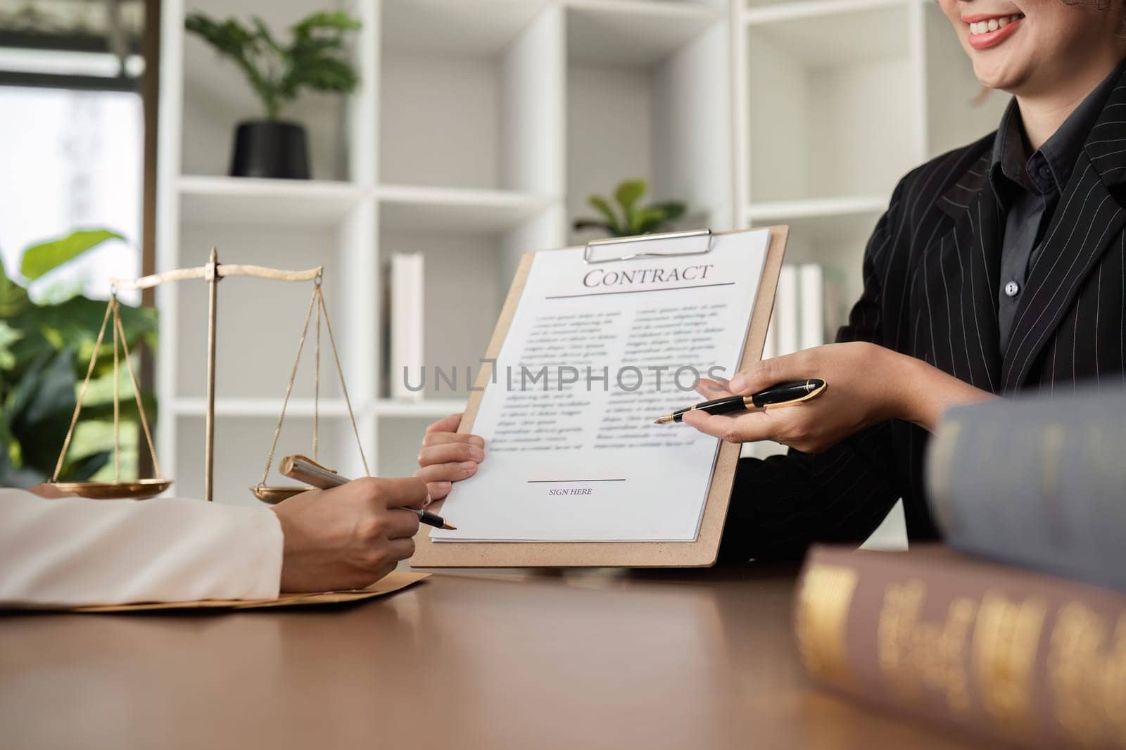 close up, Lawyer and businesswomen discussing and introducing Providing legal advice regarding signing insurance contracts or financial contracts by wichayada