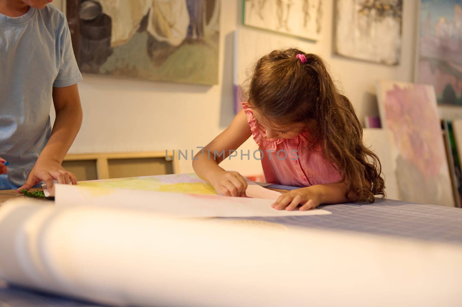 Portrait of a little girl leaning art in creative school. Confident portrait of a Caucasian little child girl enjoying her creative hobby during visual art class in primary school or art workshop