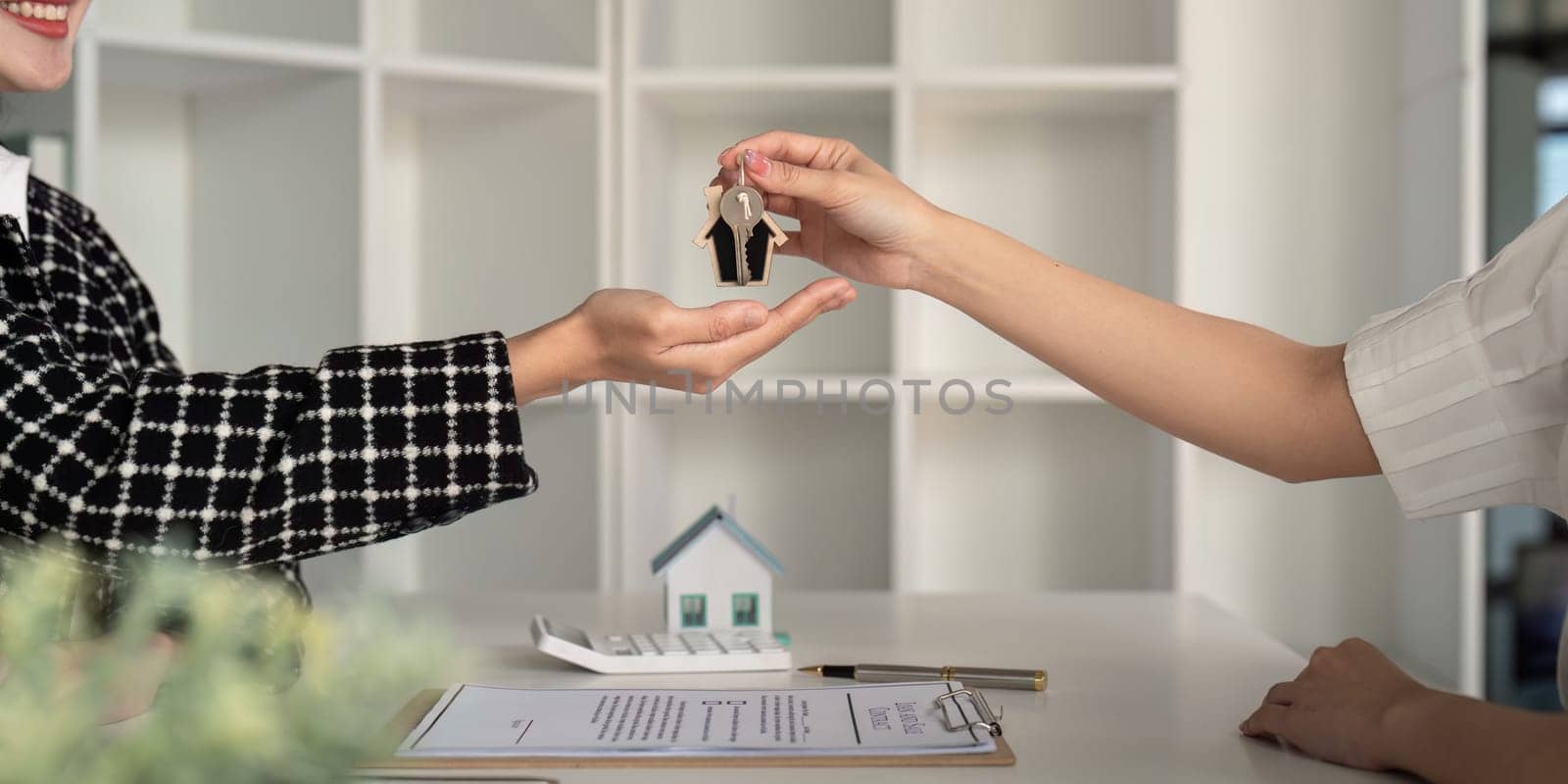 Real estate agent delivering key and home to customers and home insurance contract home mortgage loan concept.