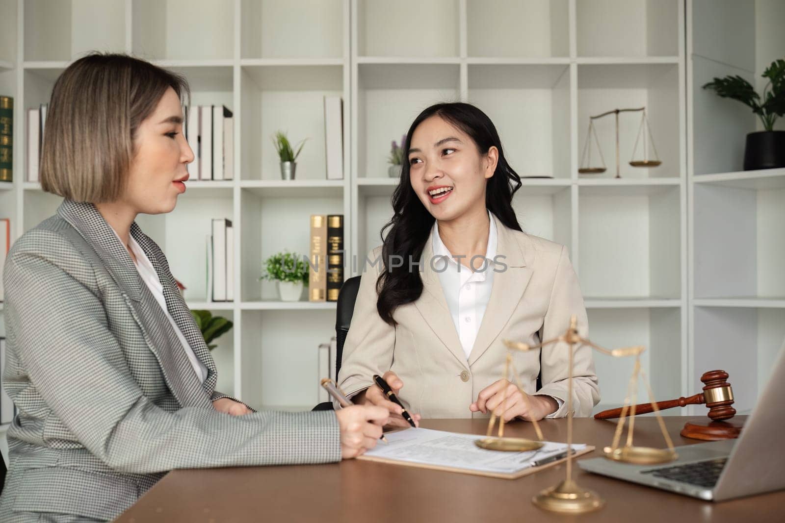 Lawyer and businesswomen discussing and introducing Providing legal advice regarding signing insurance contracts or financial contracts by wichayada