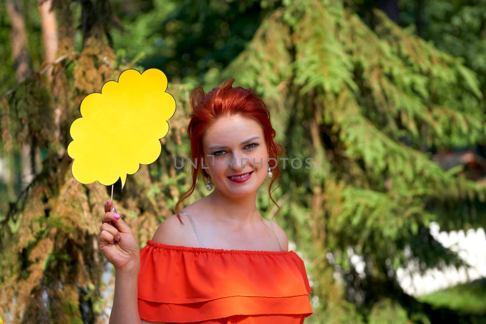 Young red haired woman in a red dress with a flyer for text in nature by jovani68