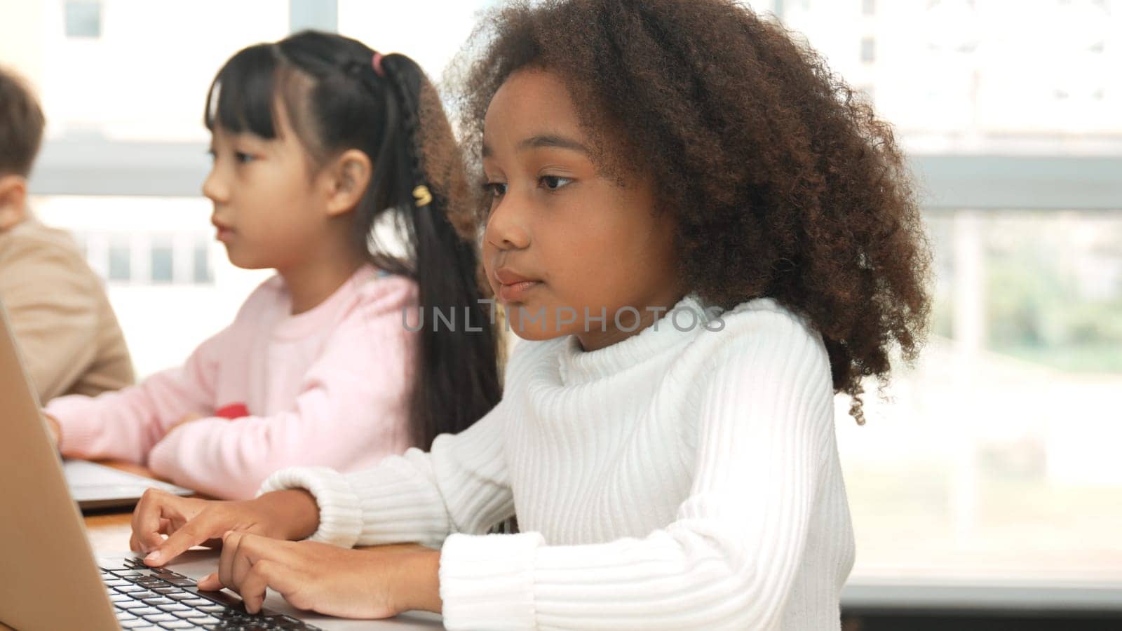 African girl play laptop with diverse friend learning prompt at STEM technology class. Multicultural student study about engineering code and programing system with blurring background. Erudition.