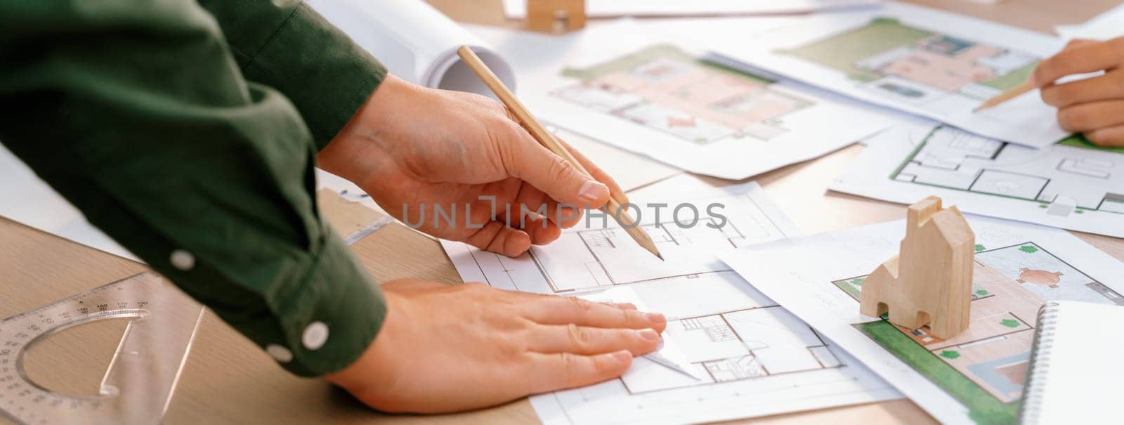 Professional engineer team discussion about house design on meeting table with architectural equipment and blueprint scatter around at modern office. Focus on hand. Closeup. Delineation.