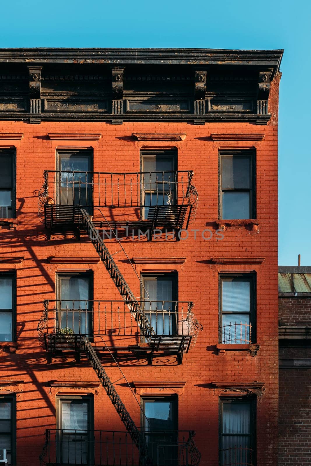 Morning Sunlight on Red Brick Building with Iron Fire Escapes in NYC by apavlin