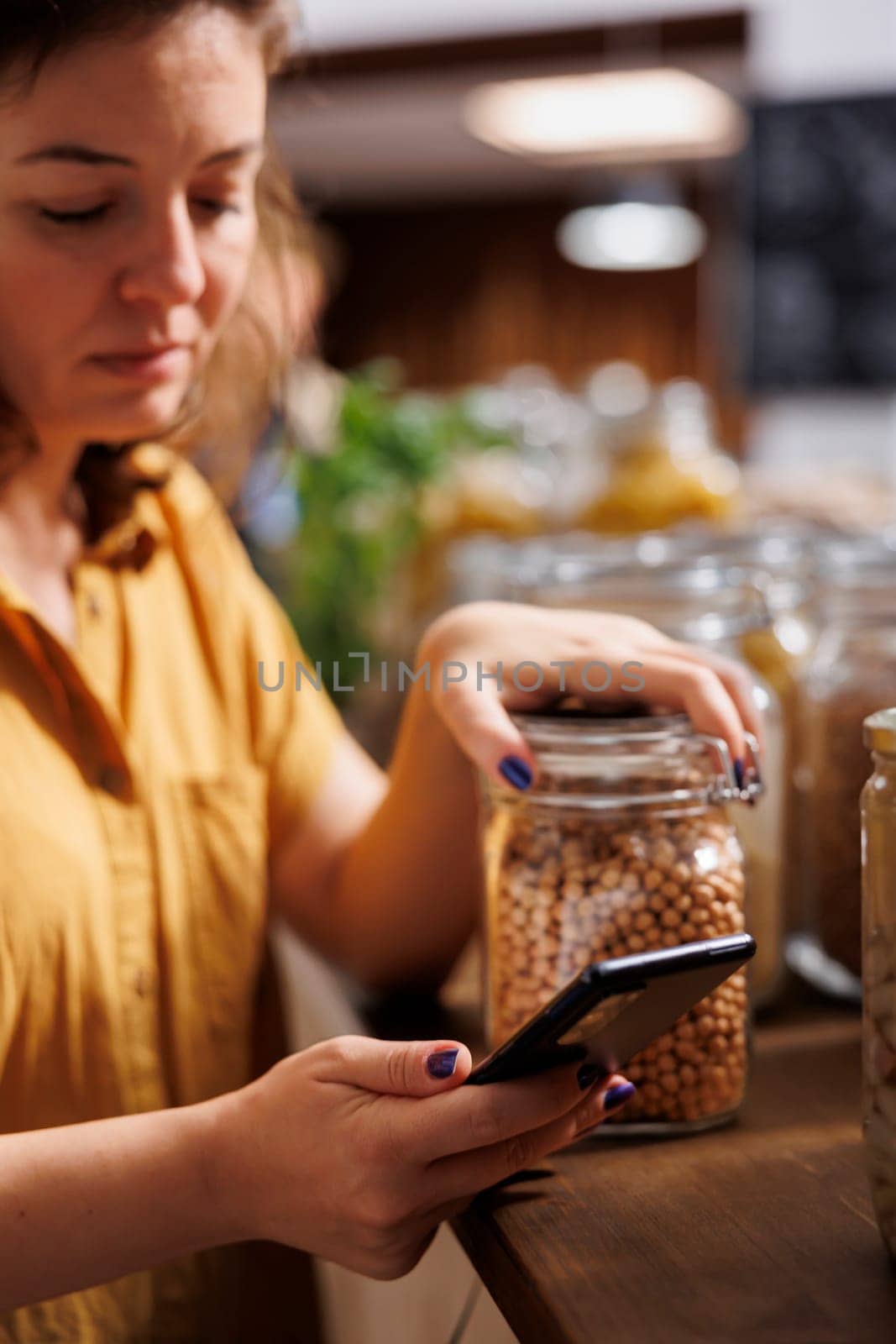Vegan woman on a diet using phone to make sure zero waste supermarket food is good for her health. Client in local neighborhood grocery store making sure products are natural