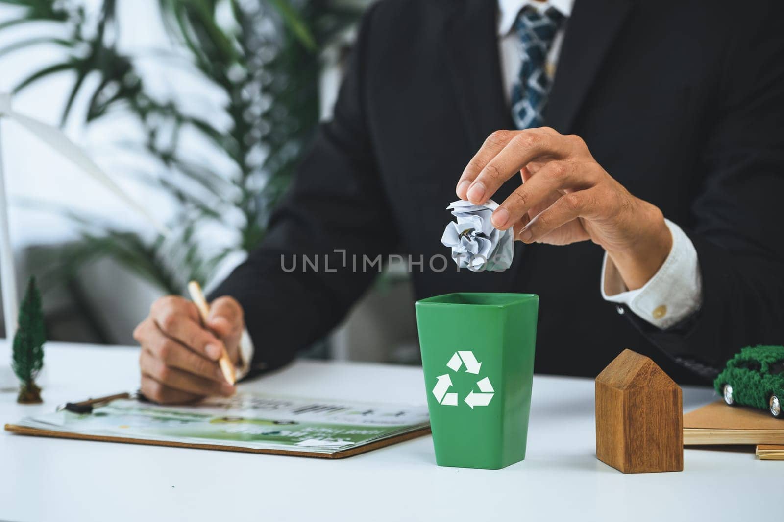 Businessman put paper waste on small tiny recycle bin in his office. Gyre by biancoblue