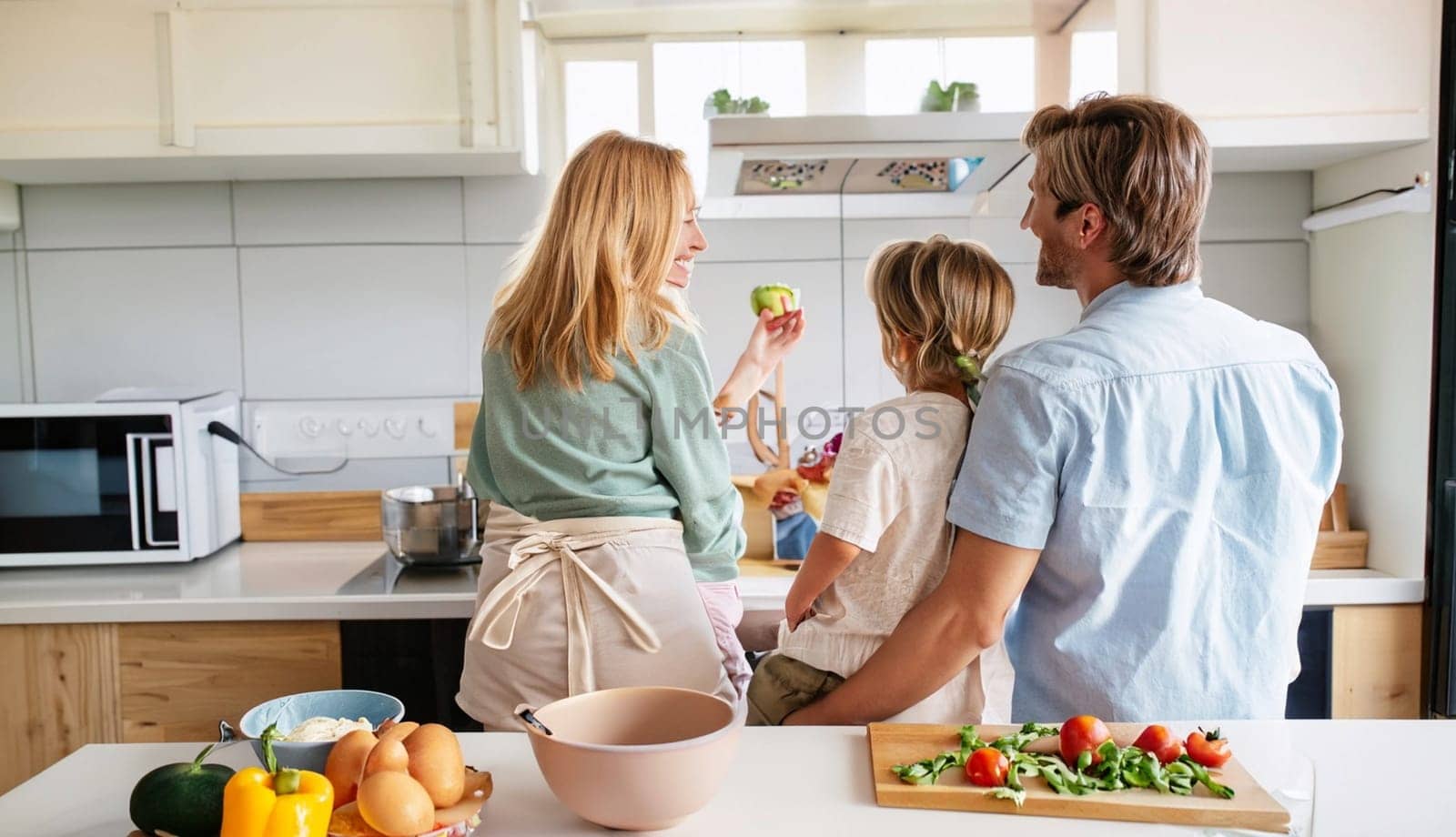 Happy family with father, mother and daughter in the kitchen, happy mom, dad and child with attachment and relationship, lifestyle and nutrition concept. High quality image