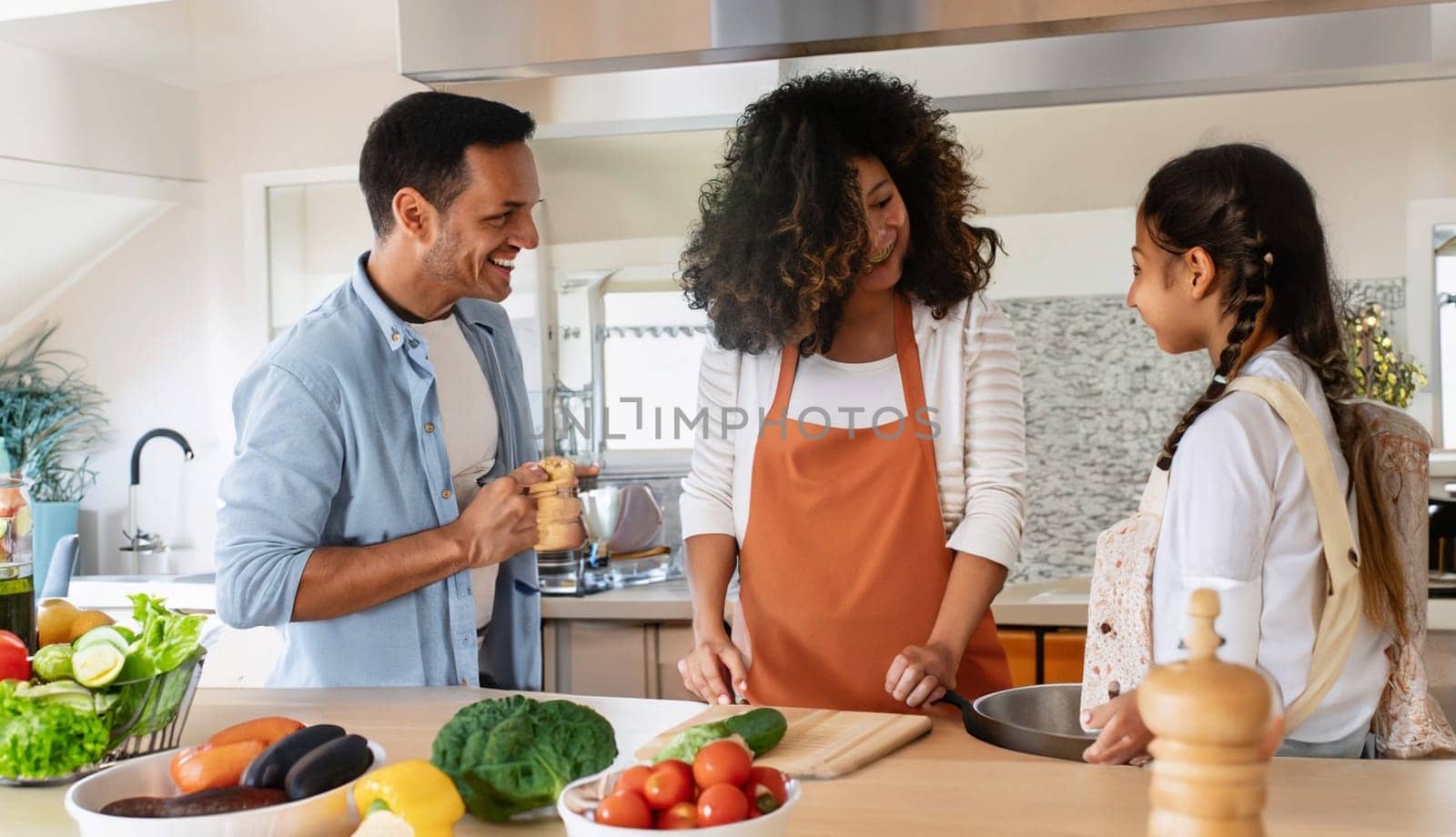 Happy family with father, mother and daughter in the kitchen, happy mom, dad and child with attachment and relationship, lifestyle and nutrition concept. by Costin