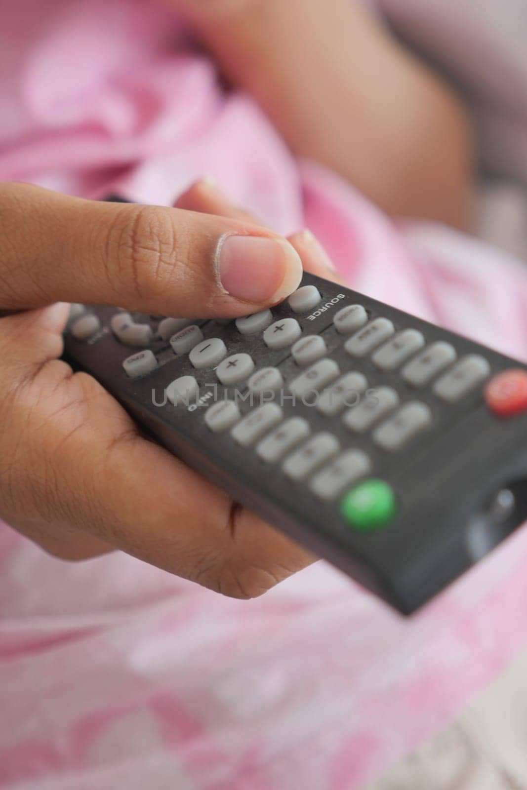 close up of women hand holding tv remote. by towfiq007