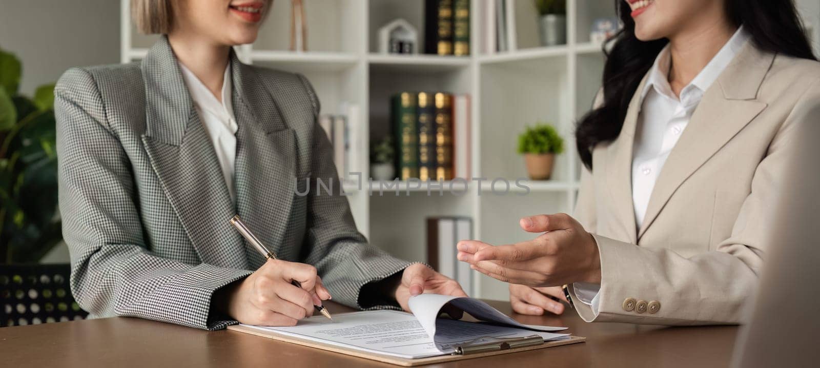 Lawyer and businesswomen discussing and introducing Providing legal advice regarding signing insurance contracts or financial contracts by wichayada