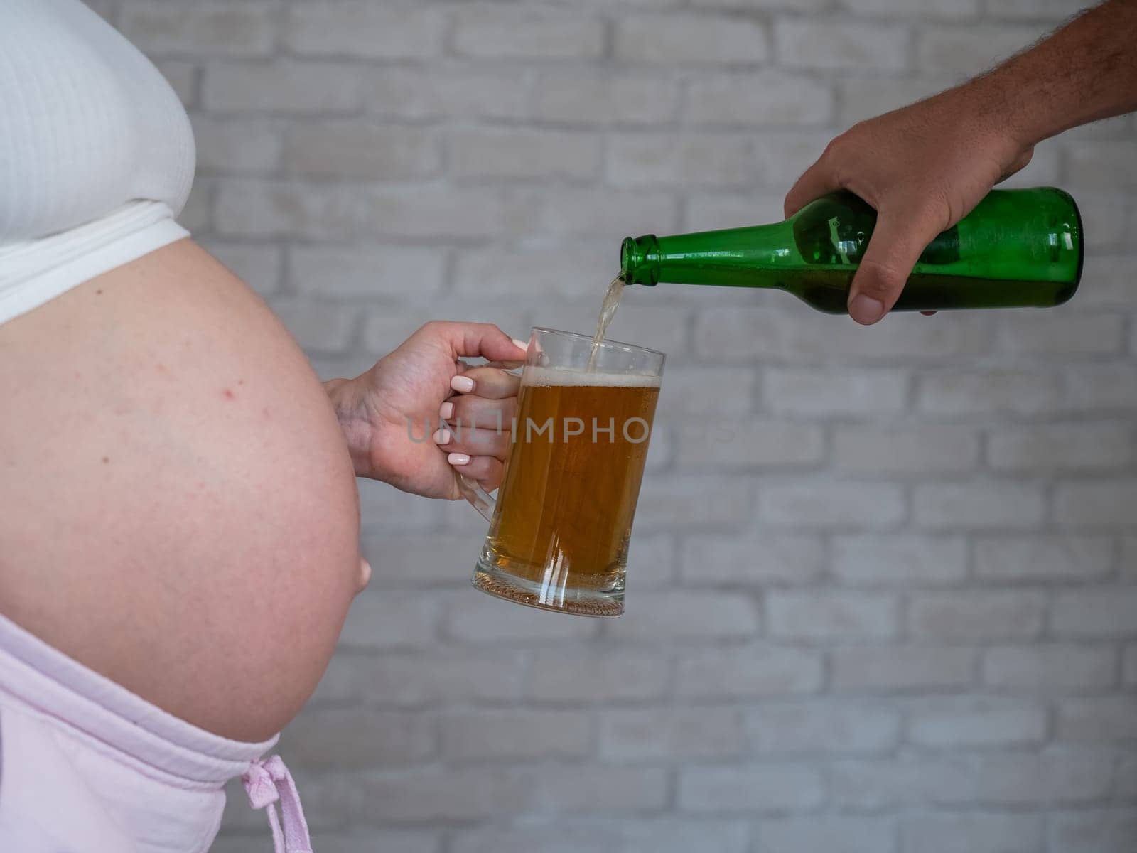 Man pouring beer for pregnant woman