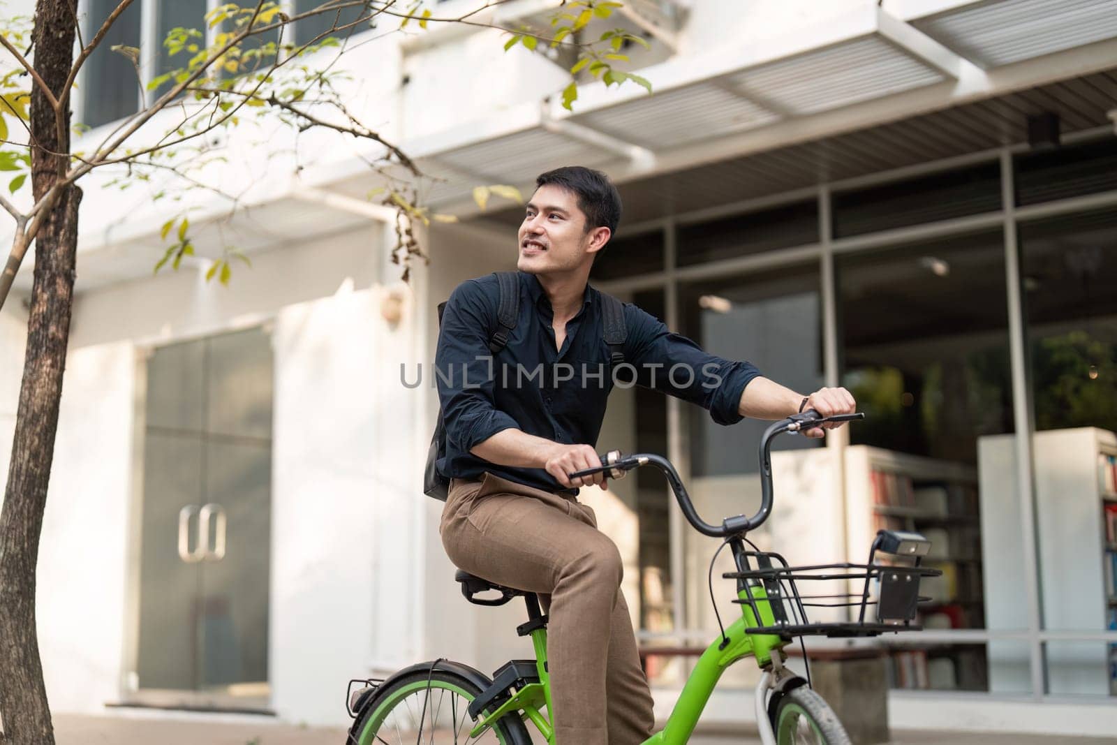 Eco friendly, Happy lifestyle asian young businessman ride bicycle go to office work at city street with bicycle in morning by nateemee