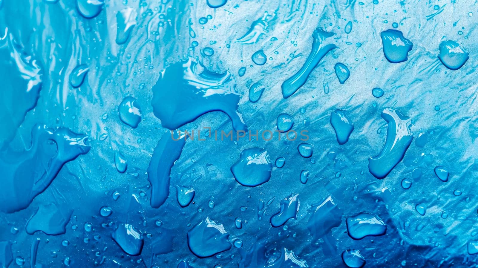 Close-up of refreshing water droplets on a vibrant blue textured background