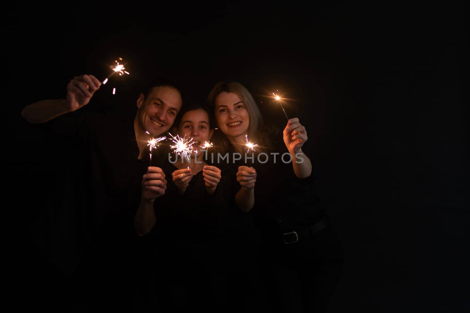 Merry Christmas and Happy Holiday. Family having fun on New Year. family with sparklers.