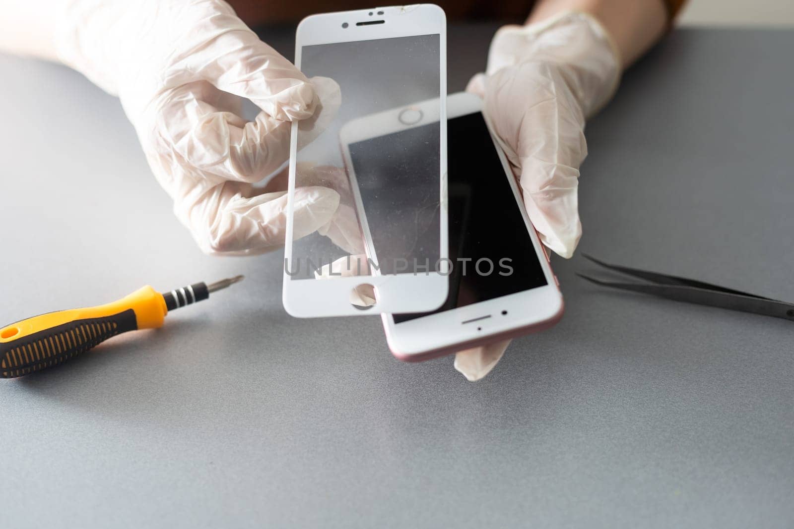 Technician prepairing to repair and replace new screen broken and cracked screen smartphone prepairing on desk. by Andelov13