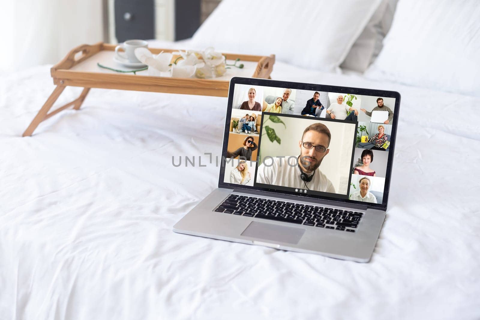 Video conference by laptop. On the laptop screen, colleagues who gathered in a video conference to work on-line. The laptop is at home