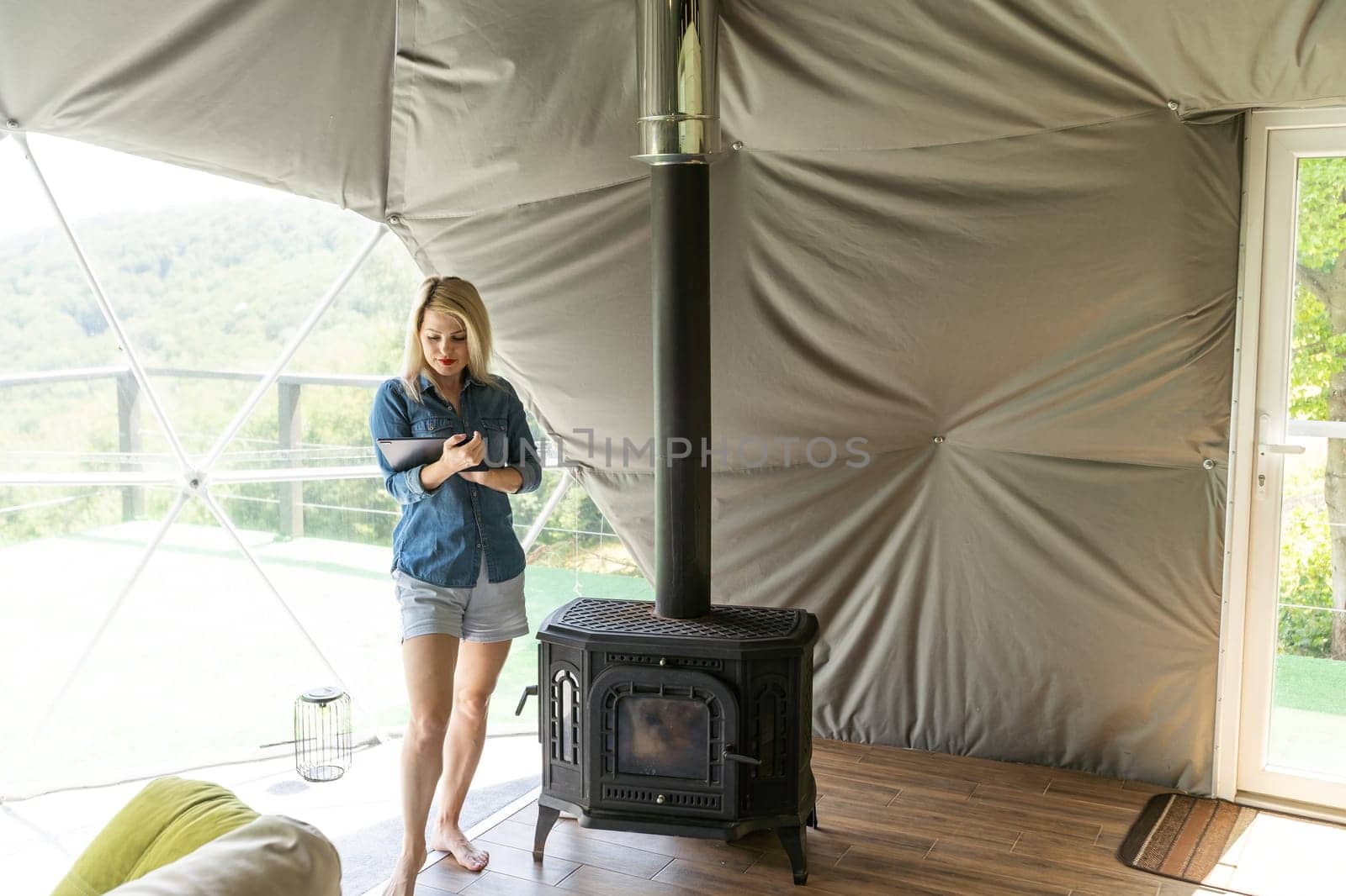 woman with tablet in dome tent.