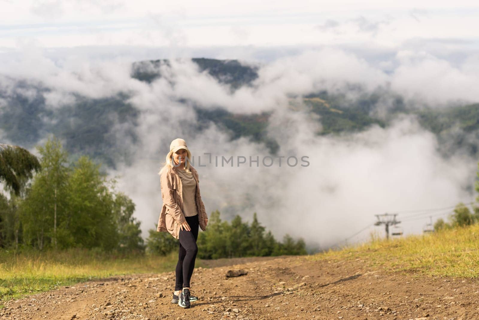 Beautiful young woman with backpack walking on meadow. Portrait of hiker girl outdoor.