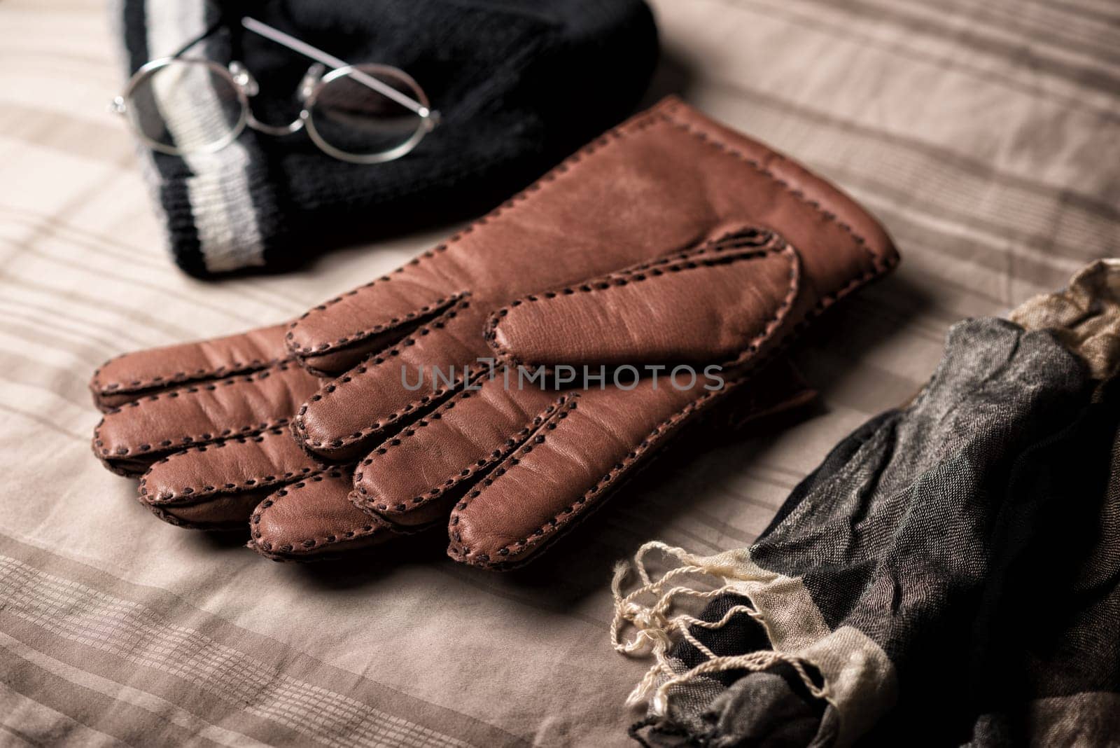 Pair of men's brown leather gloves and other men's accessories.