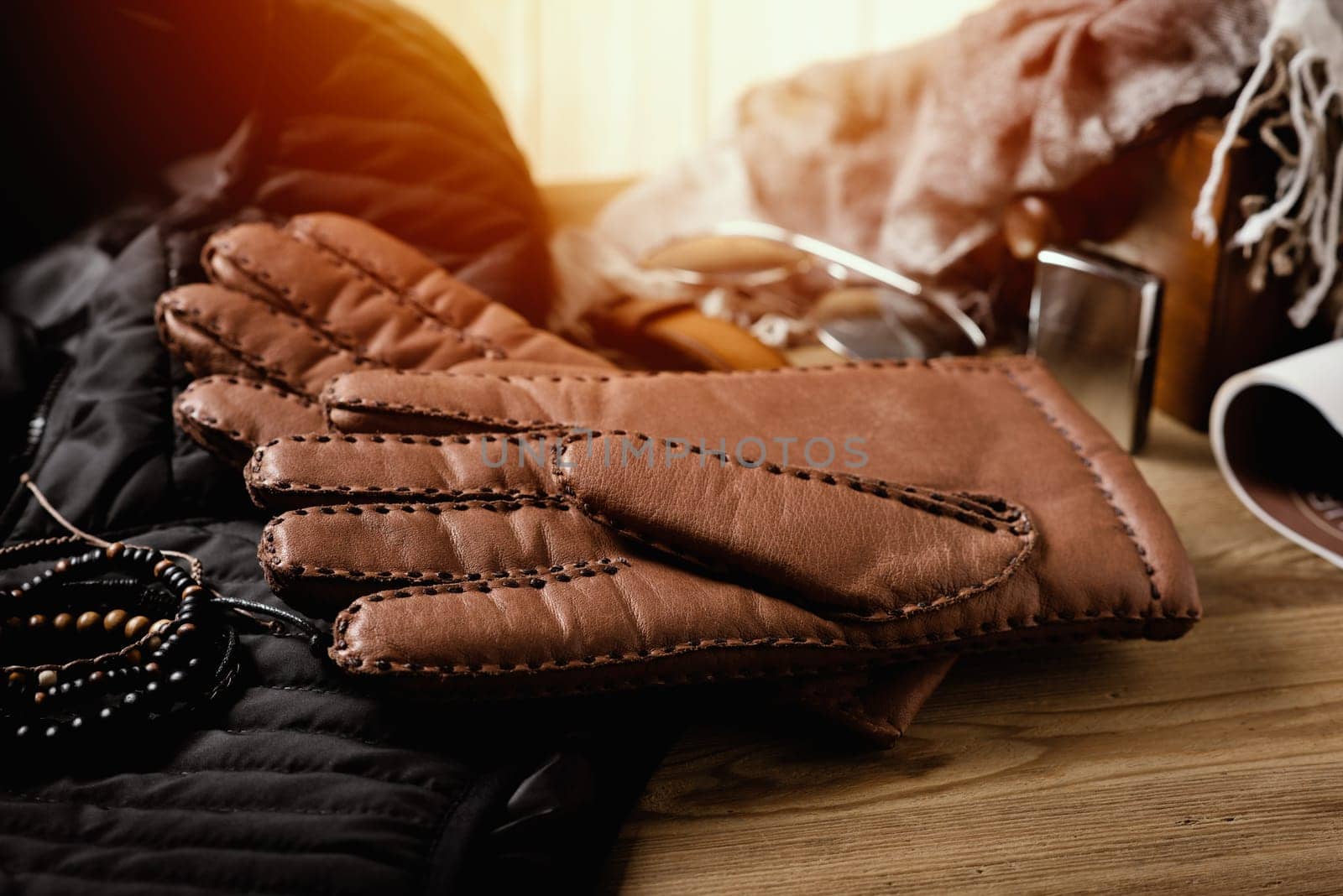 Pair of men's brown leather gloves and other men's accessories.