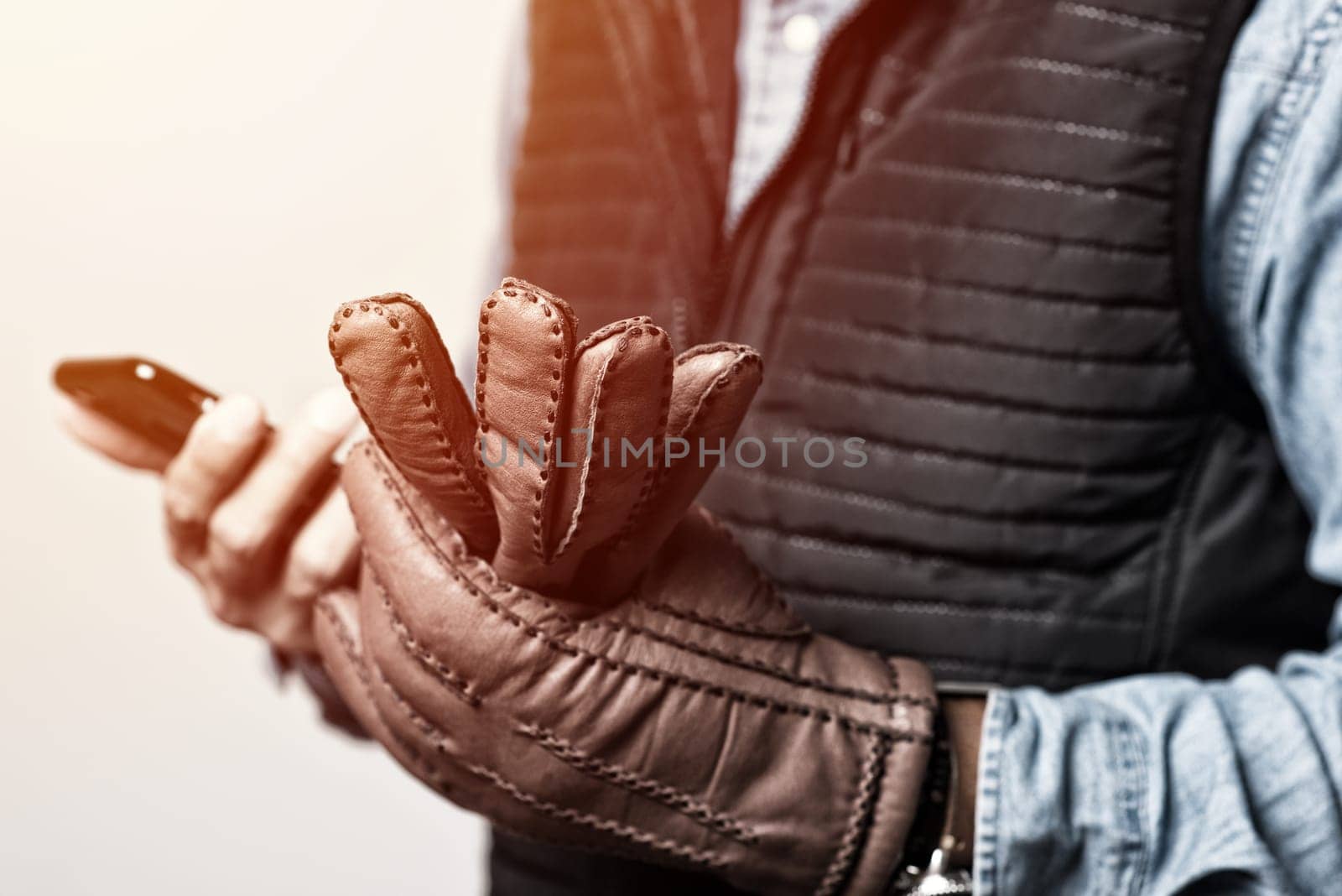 A man wearing the brown leather gloves in winter.