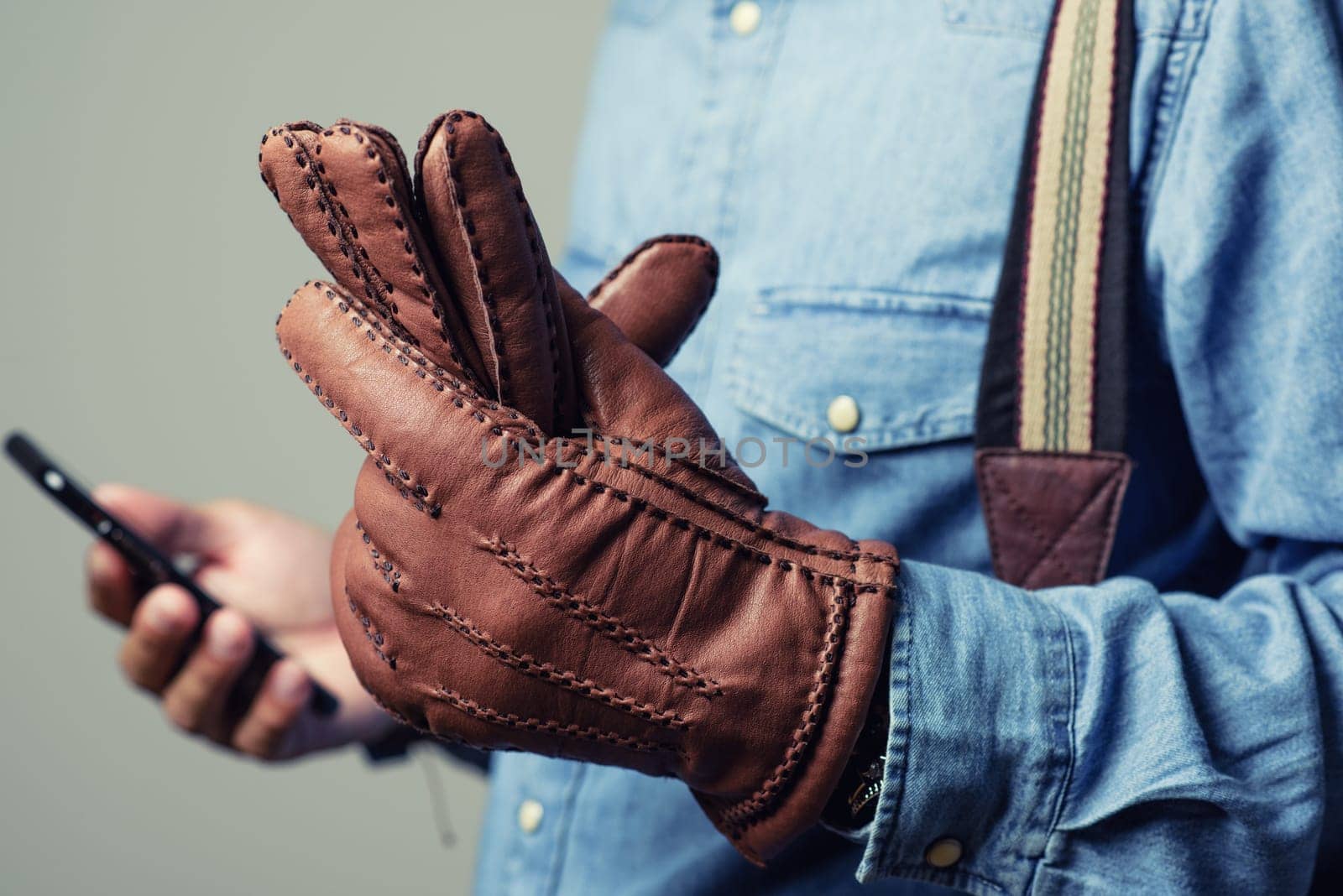 A man wearing the brown leather gloves in winter.