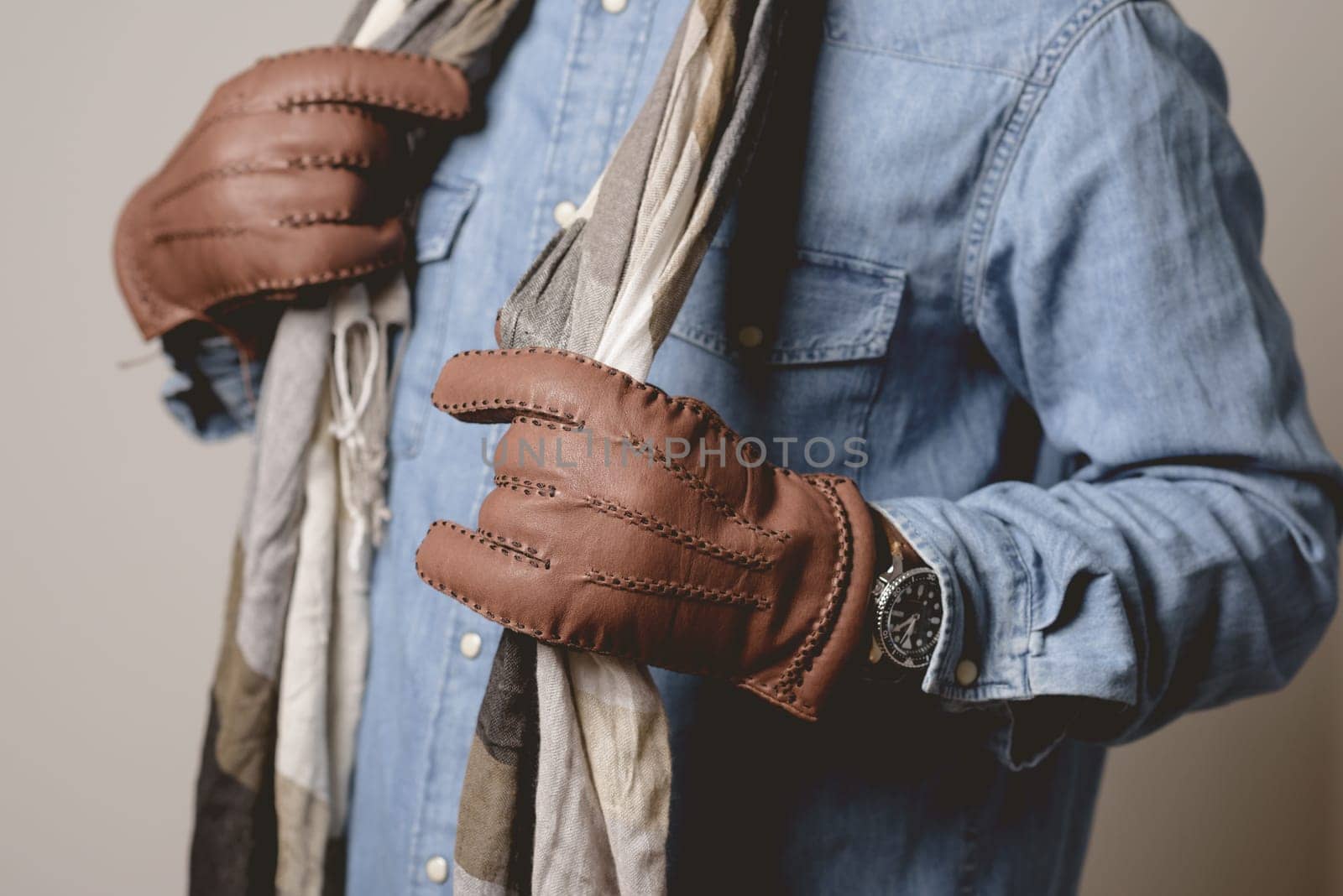 A man wearing the brown leather gloves in winter.