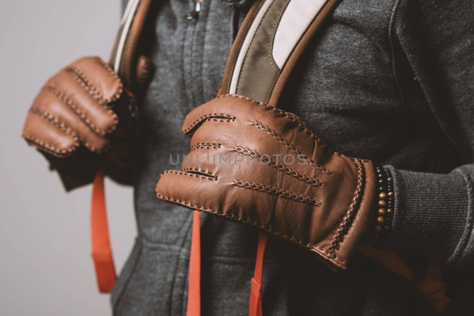 A man wearing the brown leather gloves in winter.