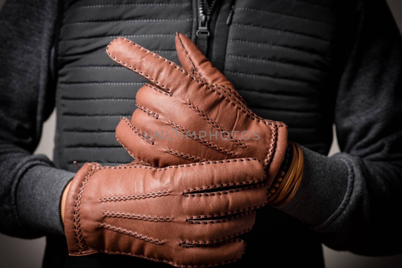 A man wearing the brown leather gloves in winter.