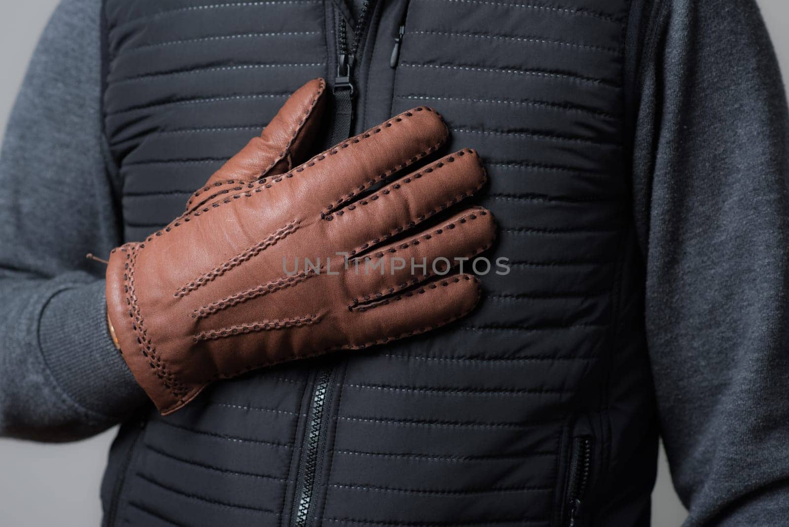 A man wearing the brown leather gloves in winter.