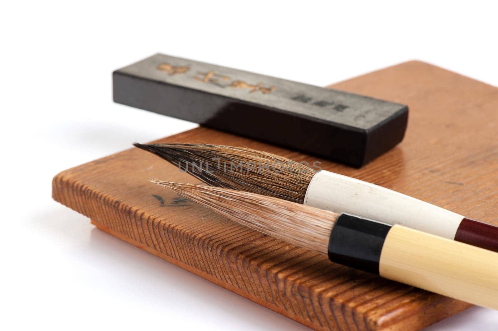 inkstone, inkstick and traditional writing brush isolated on white background