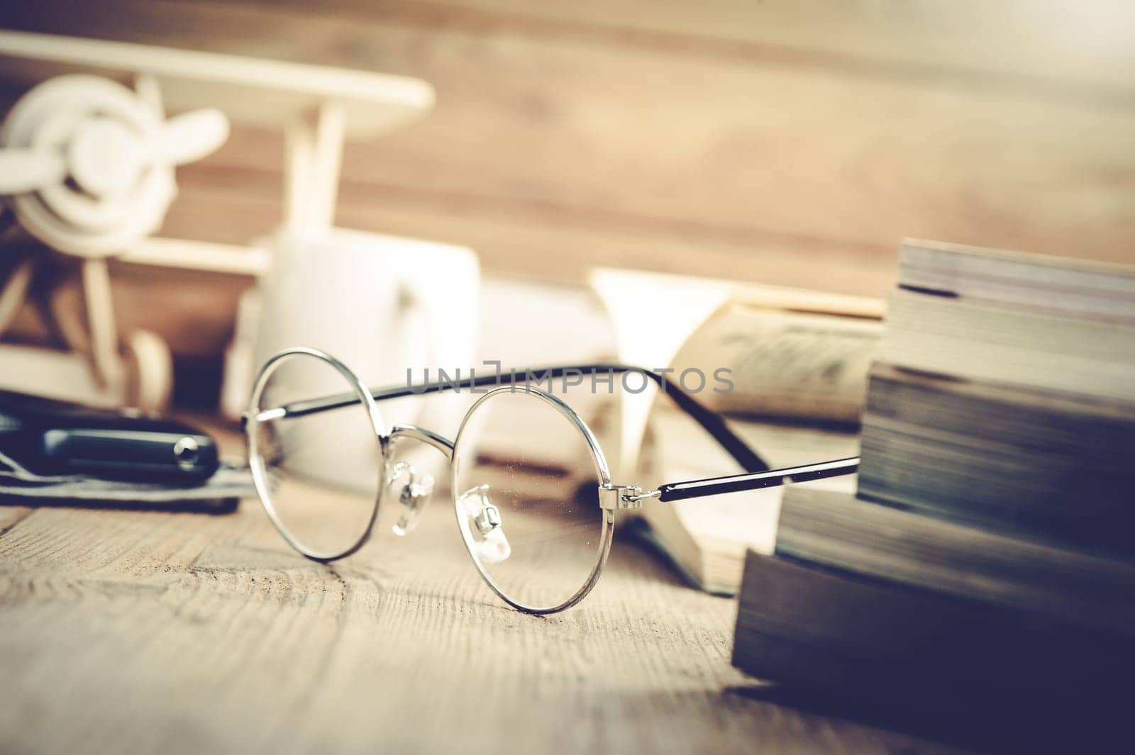 closeup round frame style of eyeglasses on wooden desk, shallow depth of field and filtered