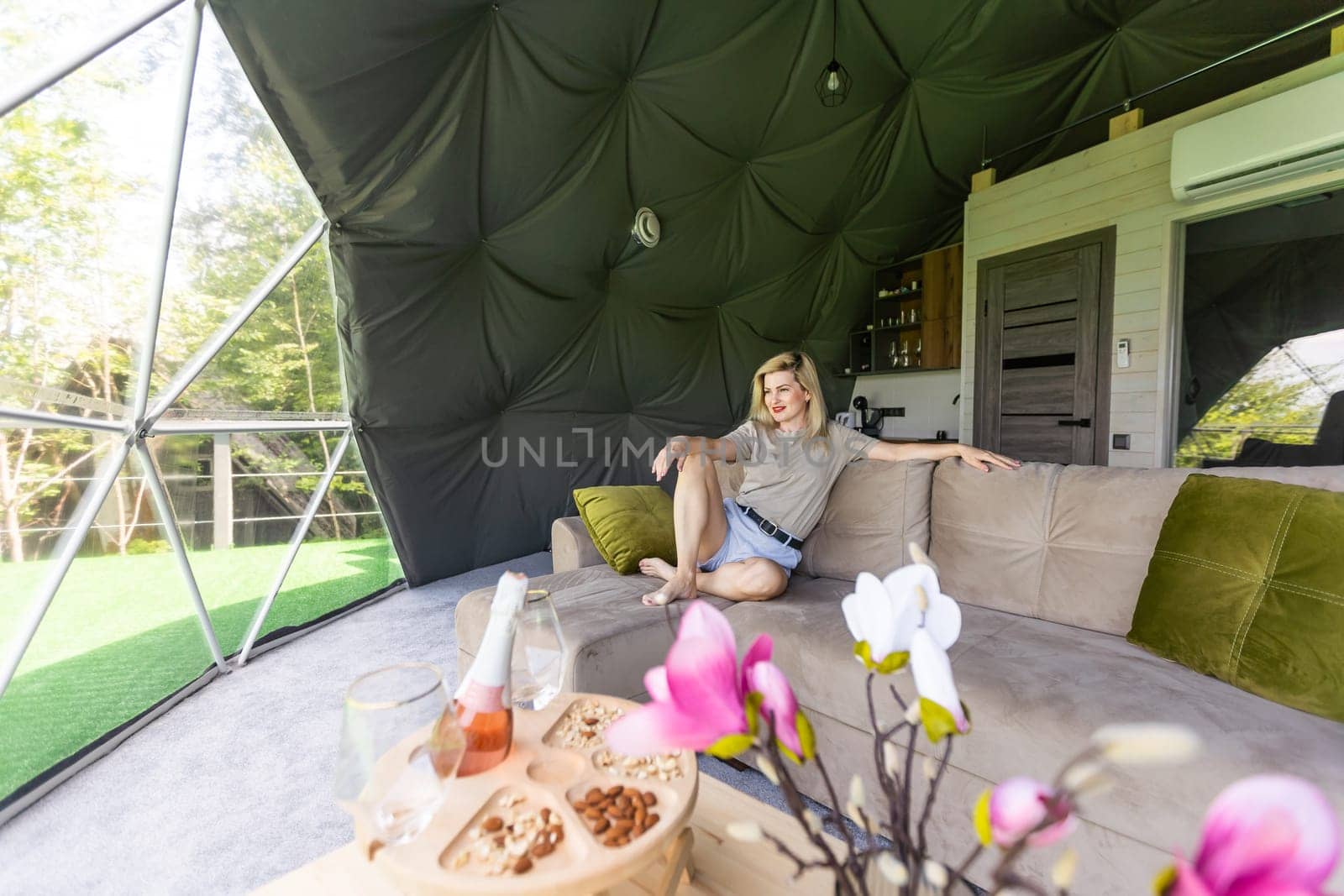 Transparent bubble tent at glamping, Lush forest around and interior. woman resting in glamping.