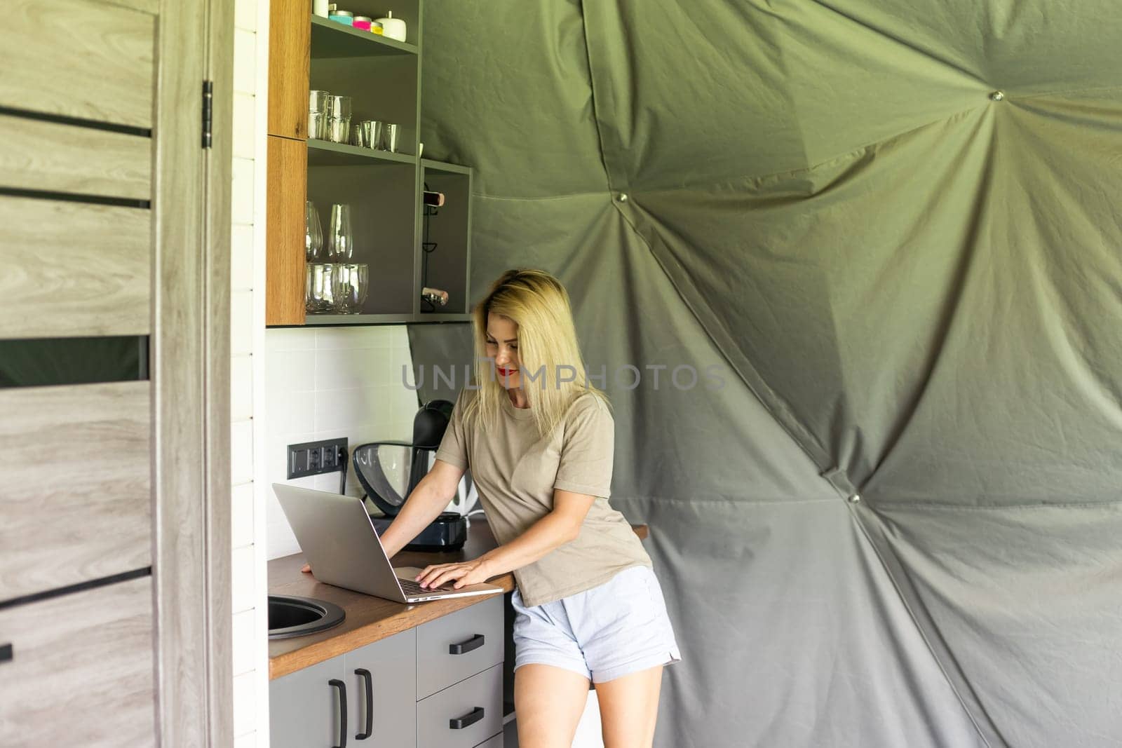 Joyful blonde girl smiling and talking via video call on laptop, home office, working remotely, explaining a strategy, freelancer, discussing a new project with team