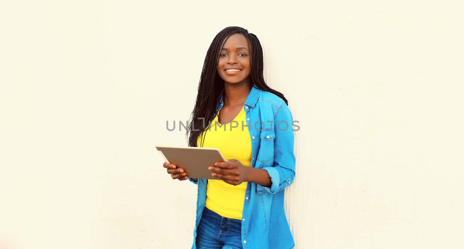 Portrait of happy smiling young african woman with tablet pc on white background