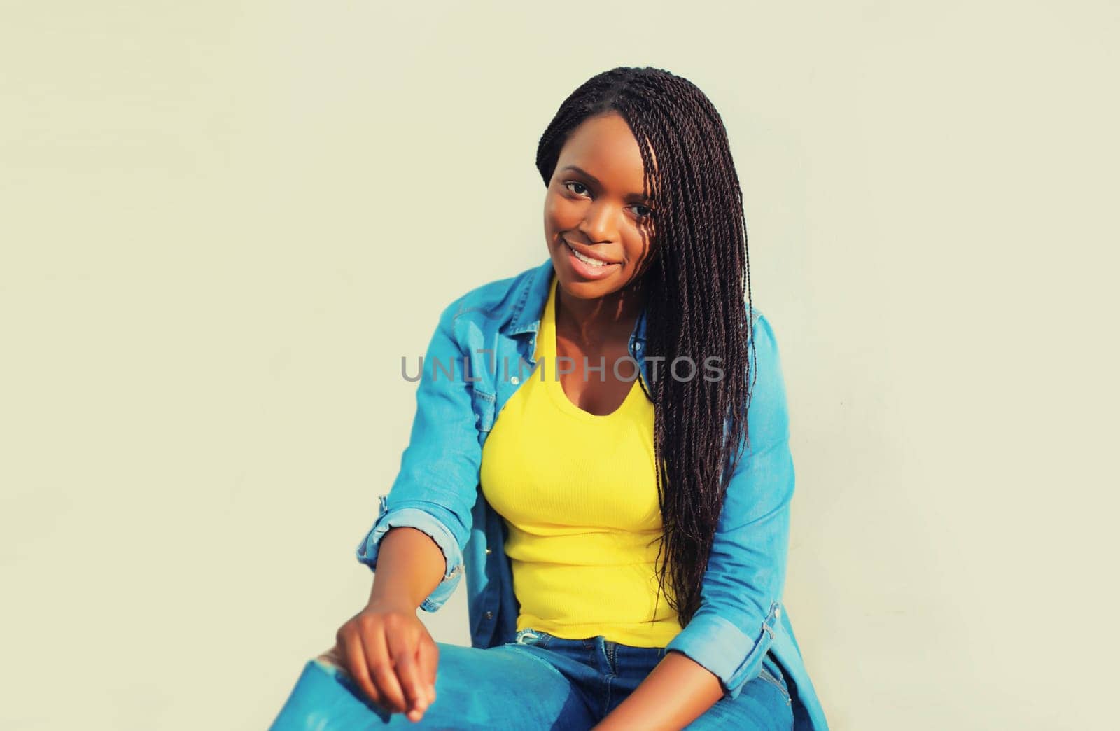 Portrait of stylish young african woman with dreadlocks posing wearing casual in the city