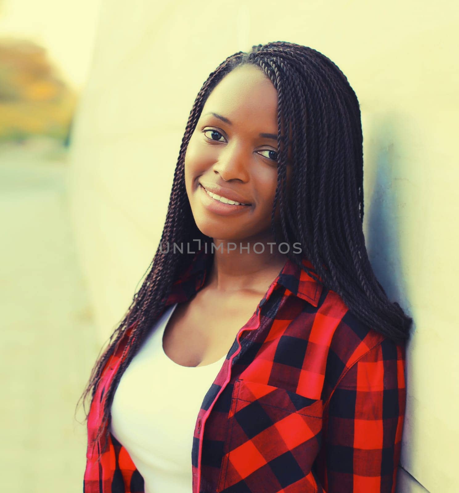 Portrait of stylish young african woman with dreadlocks posing wearing casual in the city